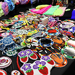 Plusieurs boucles d’oreilles et effigies colorées réalisées en perlage.