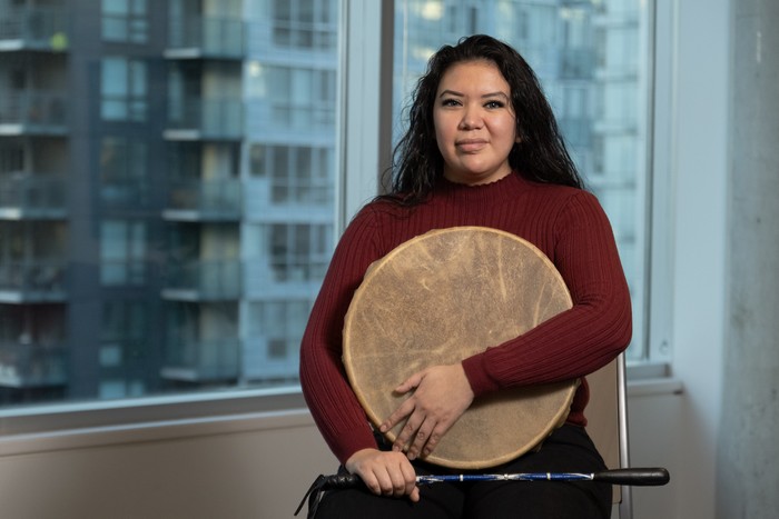 Jessica Hamilton holding a traditional drum and drumstick